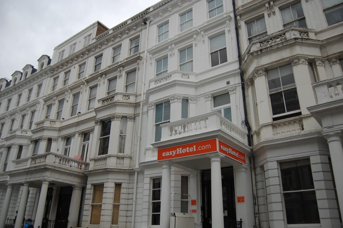 Exterior of an easyHotel in South Kensington, London, featuring a multi-story, white Victorian-style building with bay windows and balconies.